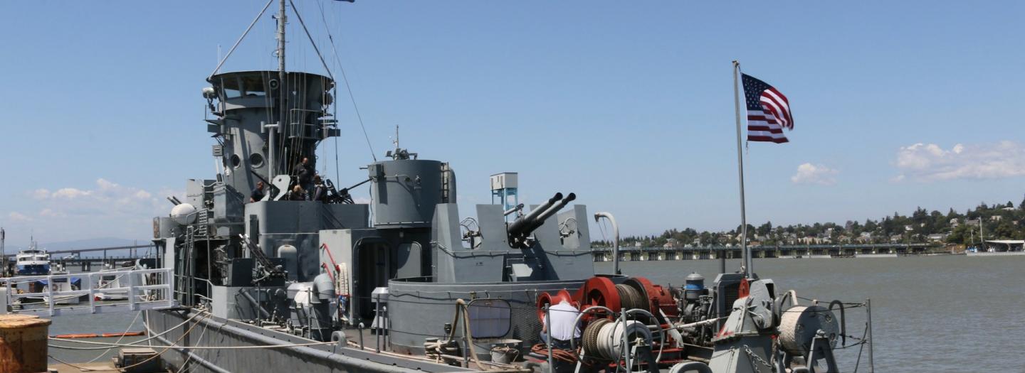 A naval vessel docked at a pier